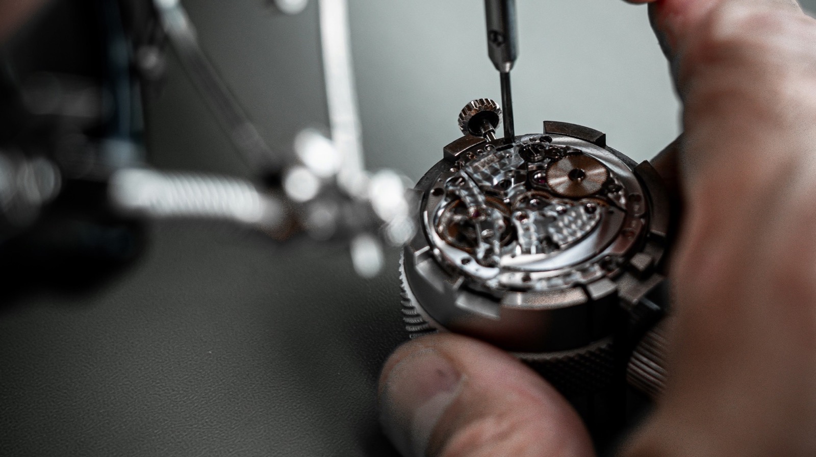 Horlogemaker werkt met een schroevendraaier aan een uurwerk in het atelier van Horloge Reparatie Centrum
